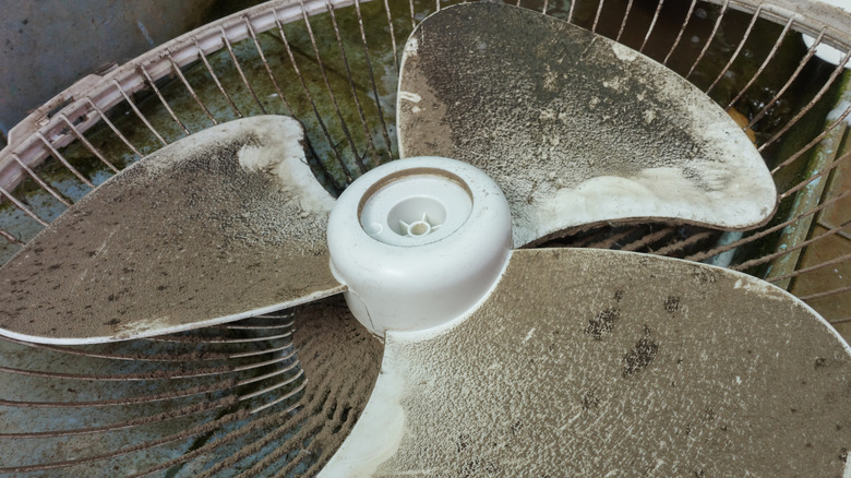 Close-up of an opened fan wheel caked in dust and dirt