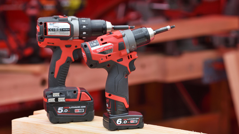 Two Milwaukee power drills on wood table