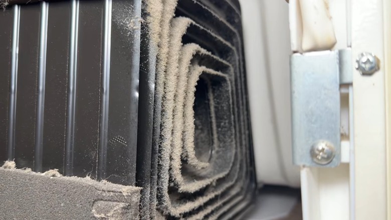 Close-up of dust-covered refrigerator cooling coils.