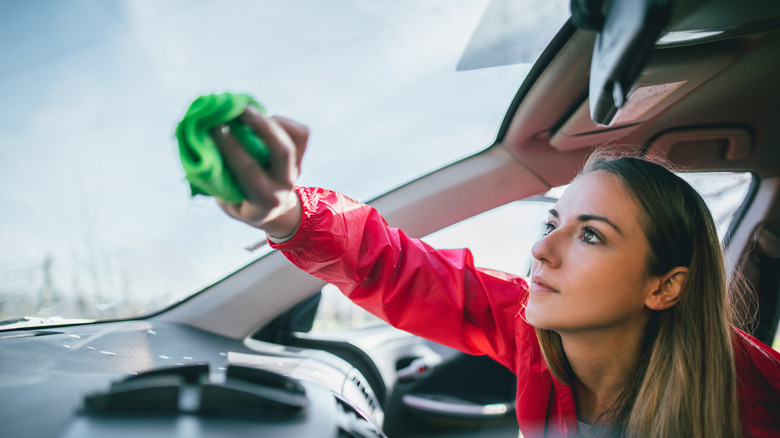 A lady cleaning a windscreen