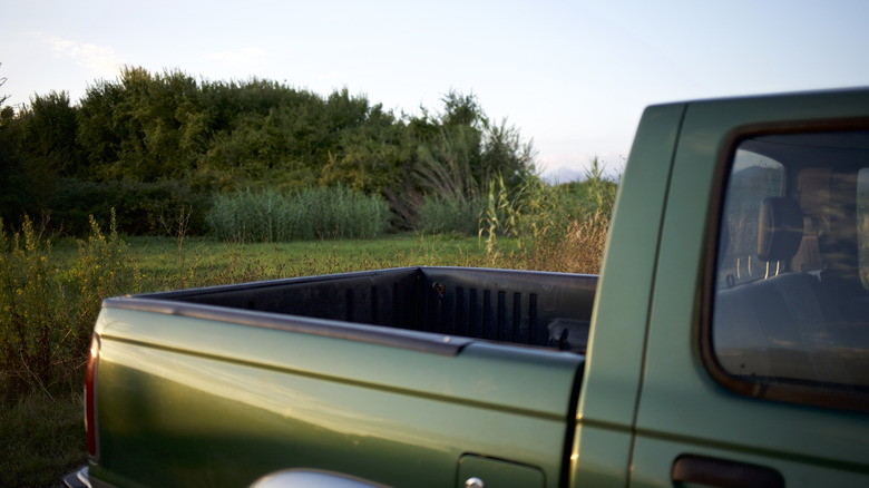 A side view of a green pickup truck's bed