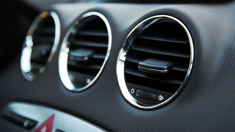 Three black circular shaped car air vents