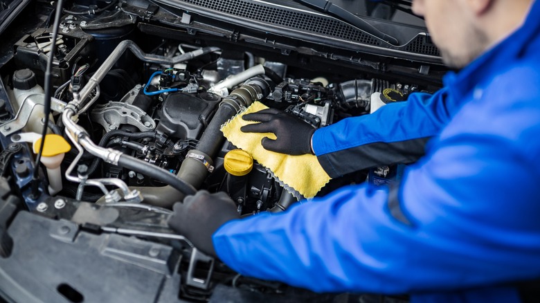Technician wipes down the engine after cleaning