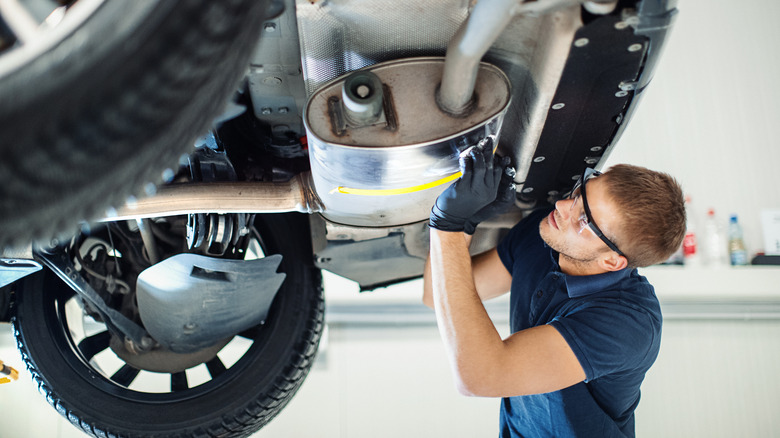 Man detailing undercarriage of car wash clean