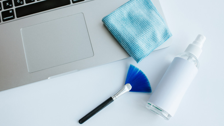 Laptop with a brush, spray and cotton cloth