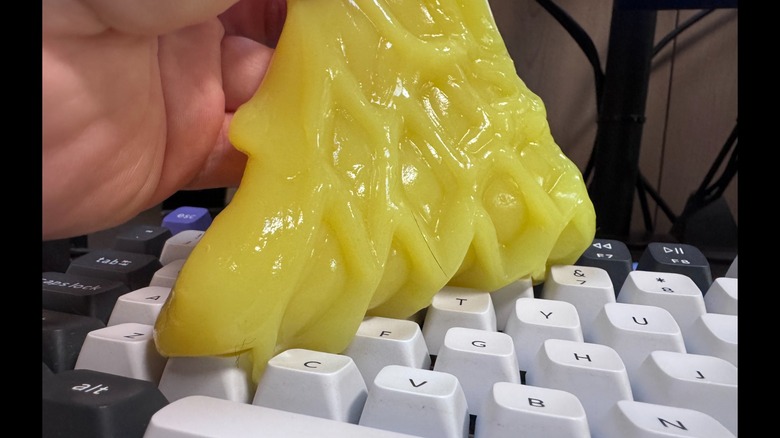 A close up shot of ColorCoral dust cleaning gel being used on a keyboard