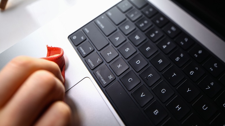 person wiping MacBook body