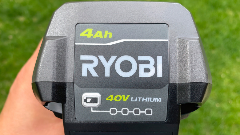 A person holding a Ryobi battery.