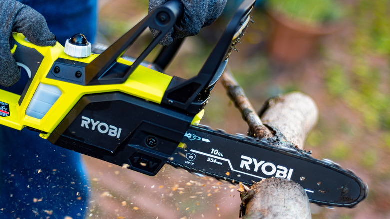 A person using a Ryobi chainsaw.