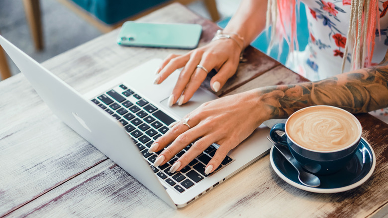 Woman using a Macbook in a coffee shop