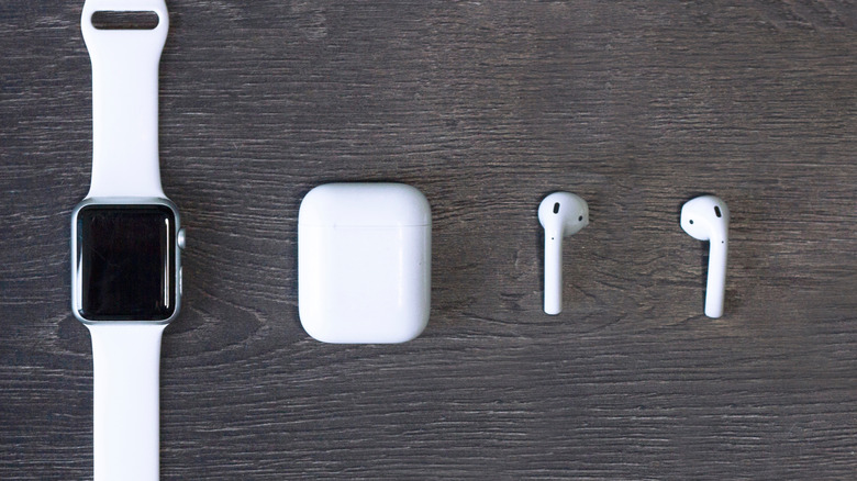 white Apple Watch next to earbuds