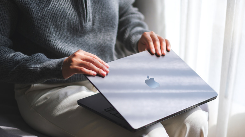 Person opening a MacBook