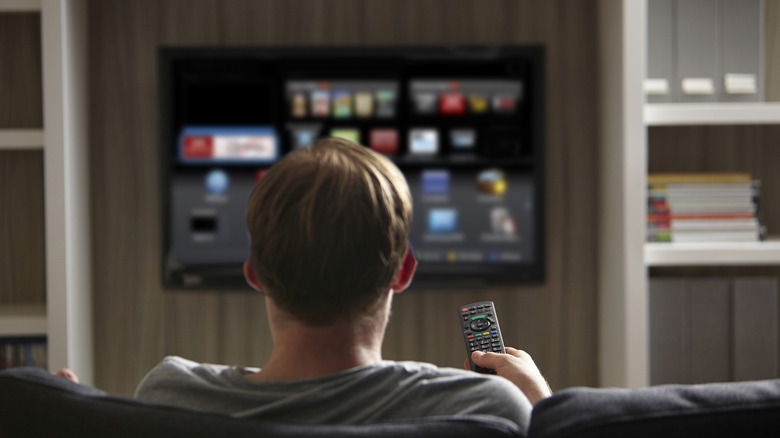 Man sitting on sofa watching TV