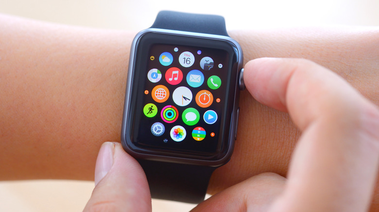 fingers pressing the Digital Crown on an Apple Watch