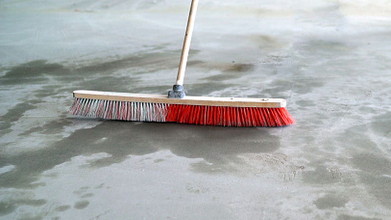 Push broom cleaning dust on a concrete floor
