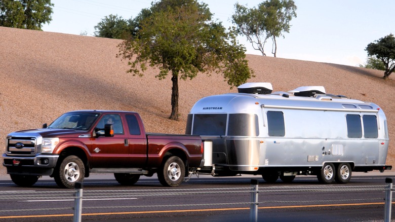 Red Ford truck towing mobile home