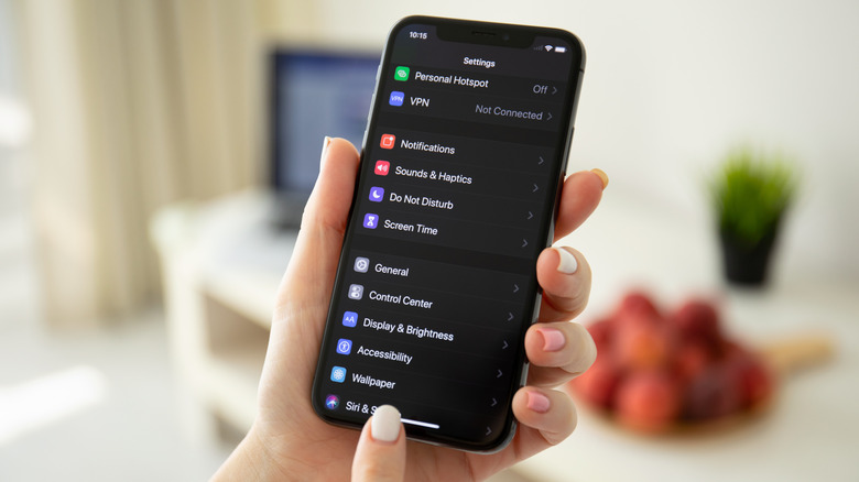 woman holding an iPhone with Dark Mode enabled