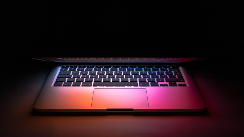 laptop in dark room with lid half closed
