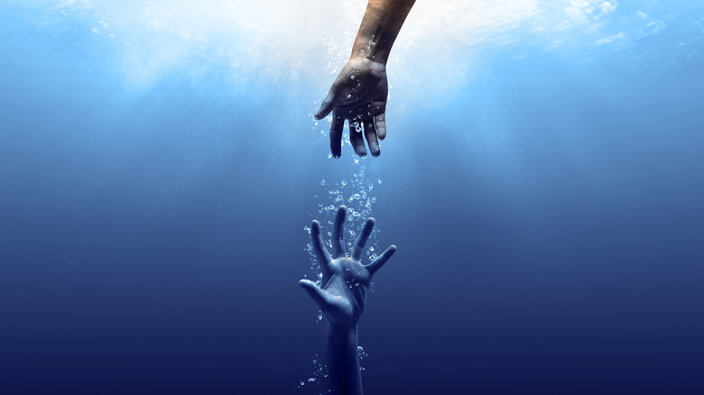 Hands trying to touch underwater