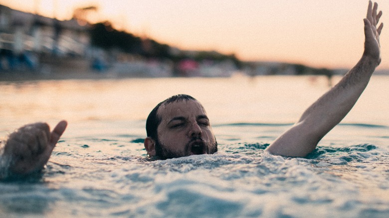 drowning person waving for help