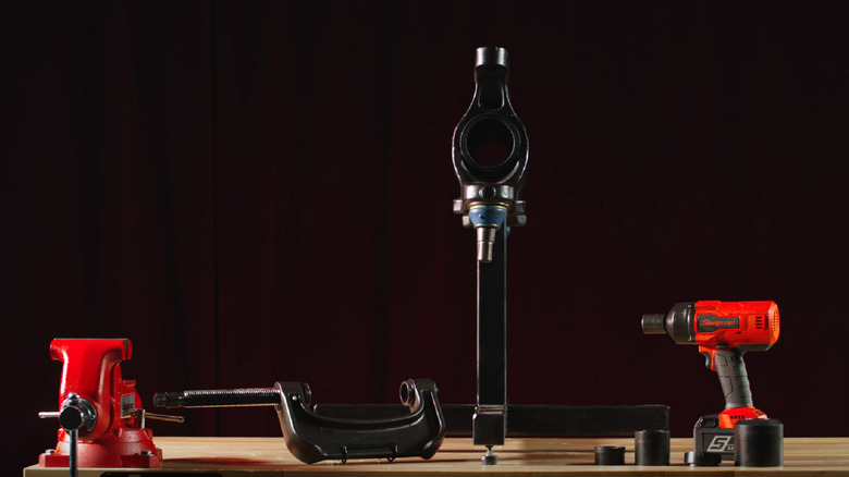 An assortment of Snap-on Tools gear laid out on a work bench including an air hammer and grip.