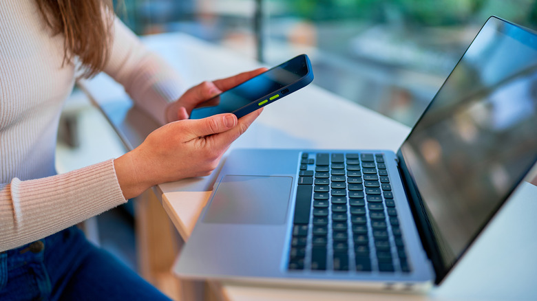 Person using smartphone laptop