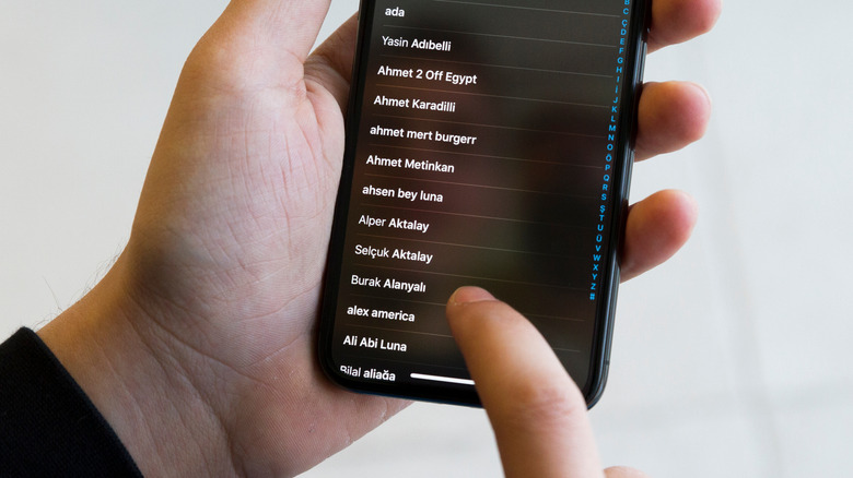 person scrolling through iphone contacts