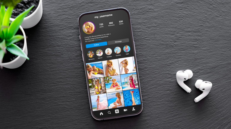 Phone on table with AirPods and plant showing Instagram account feed