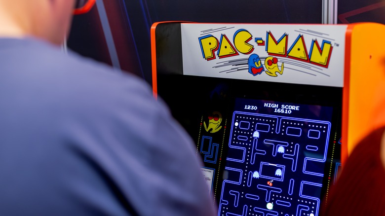 person playing Pac-Man arcade