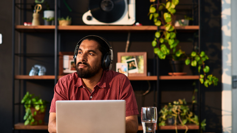 Person wearing headphones and using laptop
