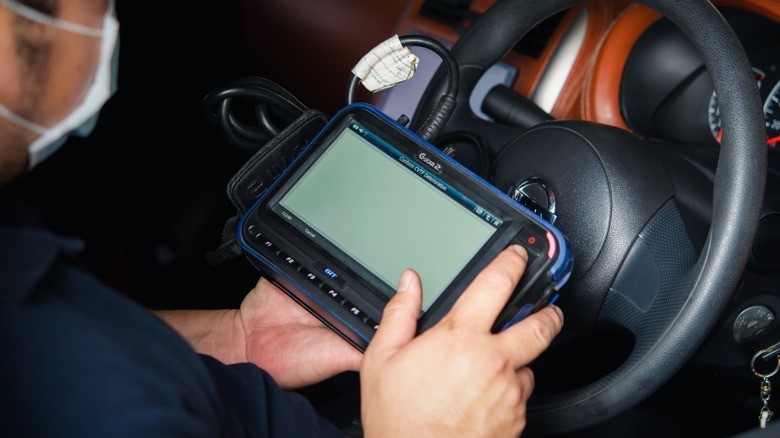 Mechanic using an OBD-II diagnostics tool