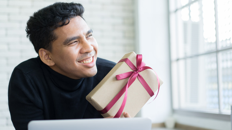 Person smiling holding gift box