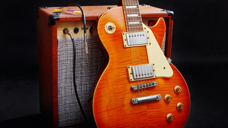 Les Paul leaning on guitar amp