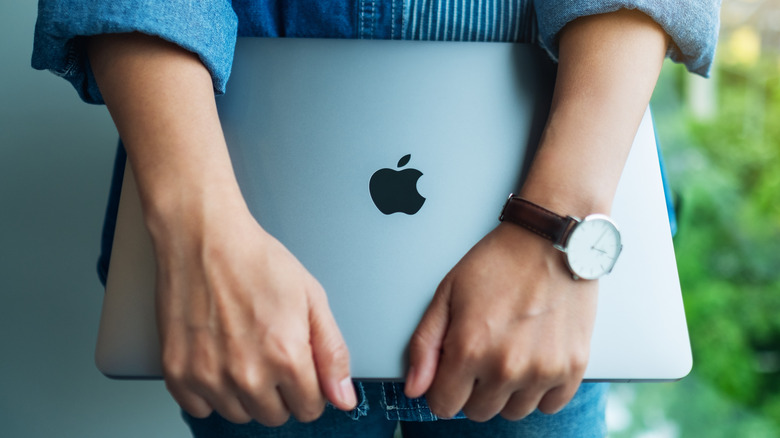 Person holding an Apple MacBook