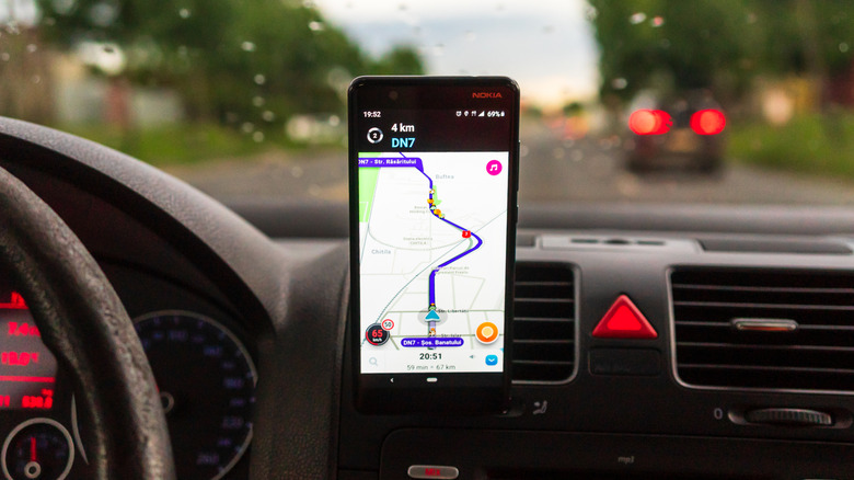 Waze app showing navigation on an Android phone mounted on a car dashboard