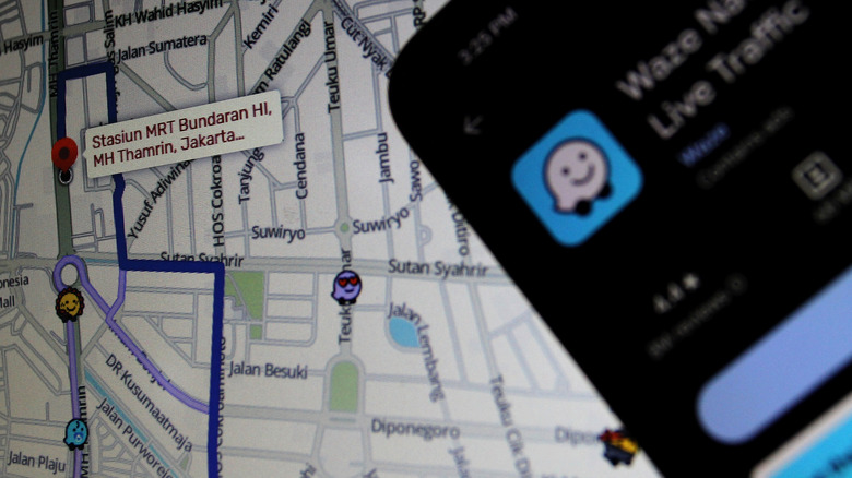 Logo of the Waze app shown on a mobile phone with a map in the background