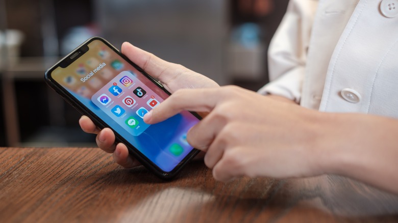 person pointing Safari icon smartphone