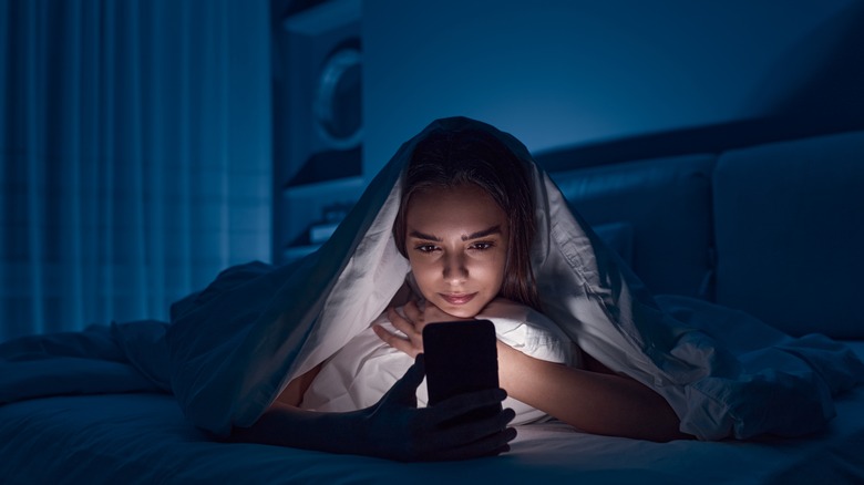 Girl using smartphone in bed