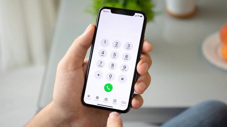 person holding iPhone dial pad