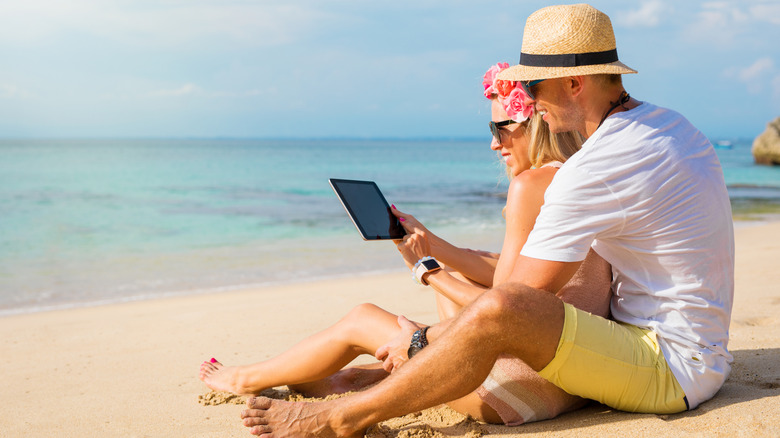 couple using iPad near water