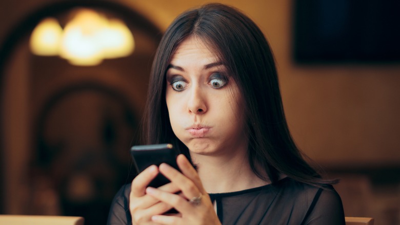 Annoyed woman holding phone
