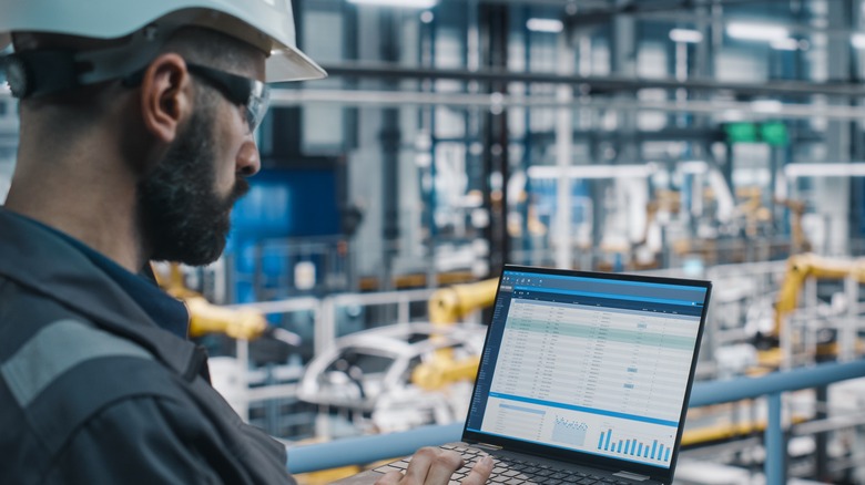 worker with hard hat looking at spreadsheet