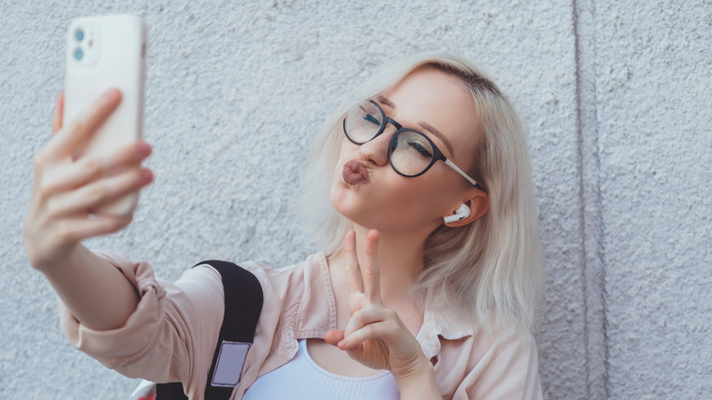 Woman taking selfie with iPhone