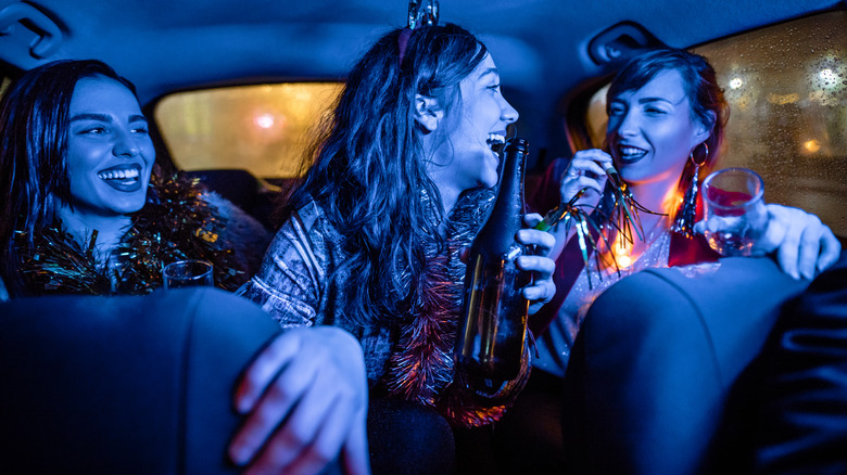 passengers drinking in back seat of an Uber or similar ride share