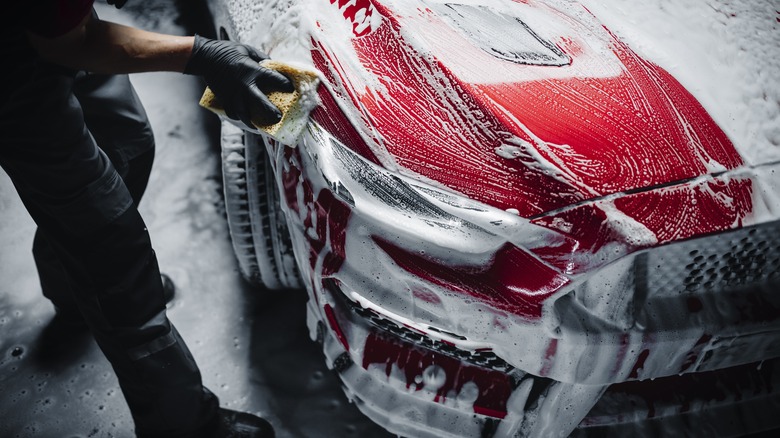 Man washing a red car