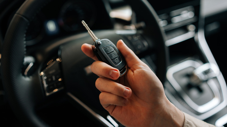 person holding car key inside the car