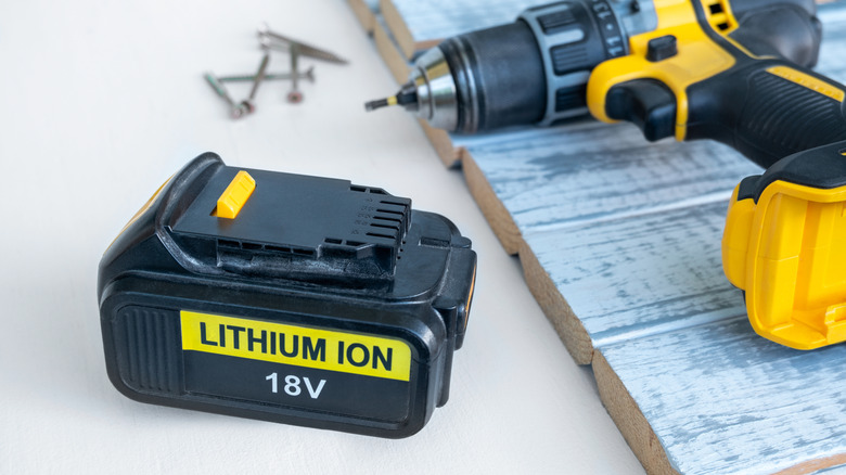 Tool battery on table with nails