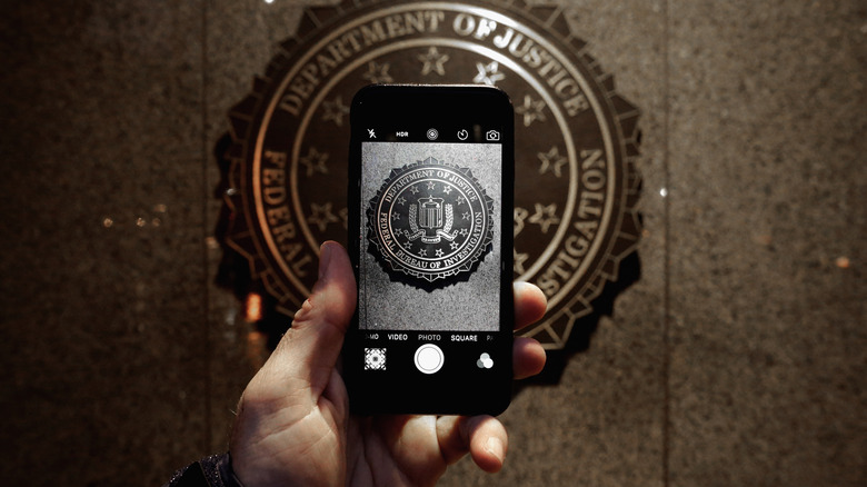 Looking at FBI seal through phone.