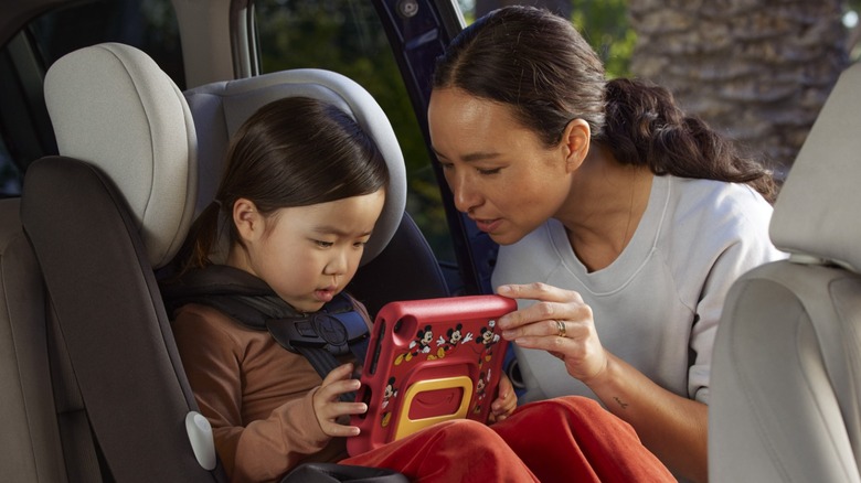 Mom assisting child with tablet