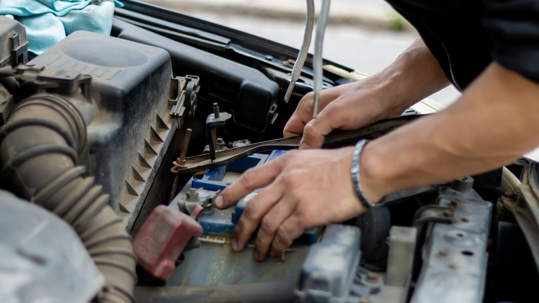 A driver replacing the car battery